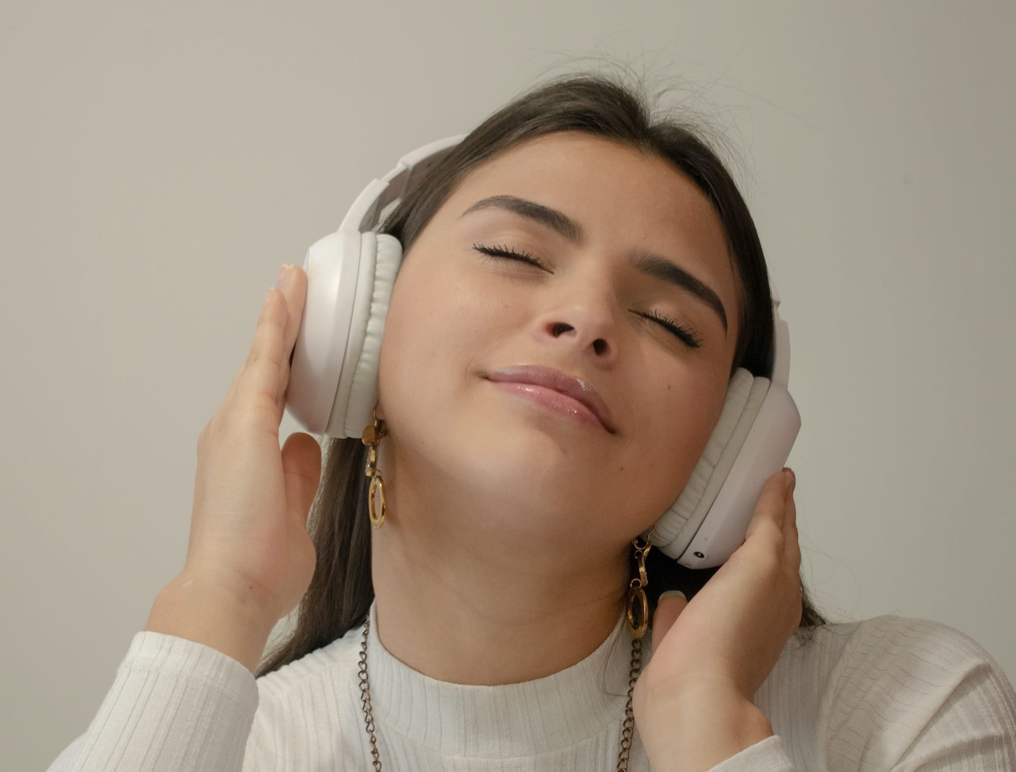 a woman with her eyes closed holding a phone to her ear