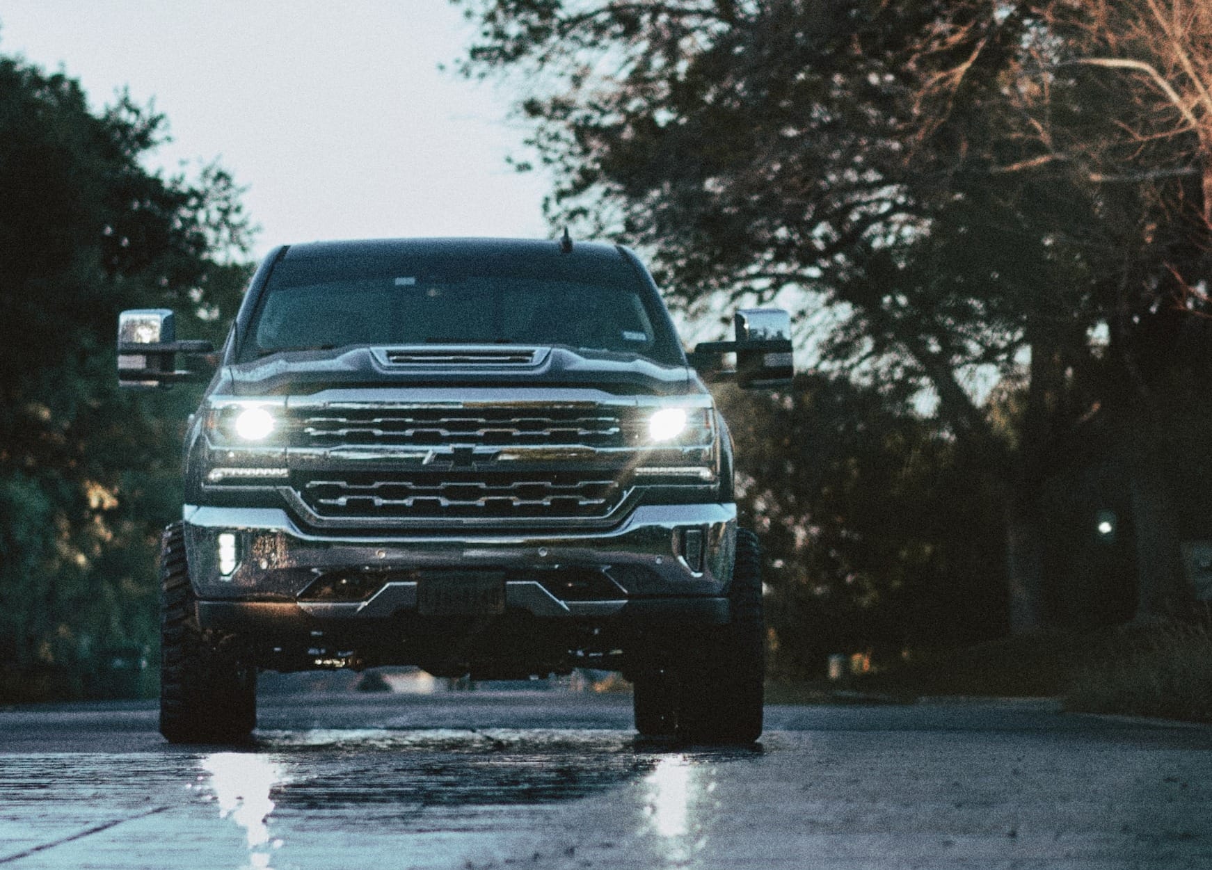 a truck is driving down a wet road