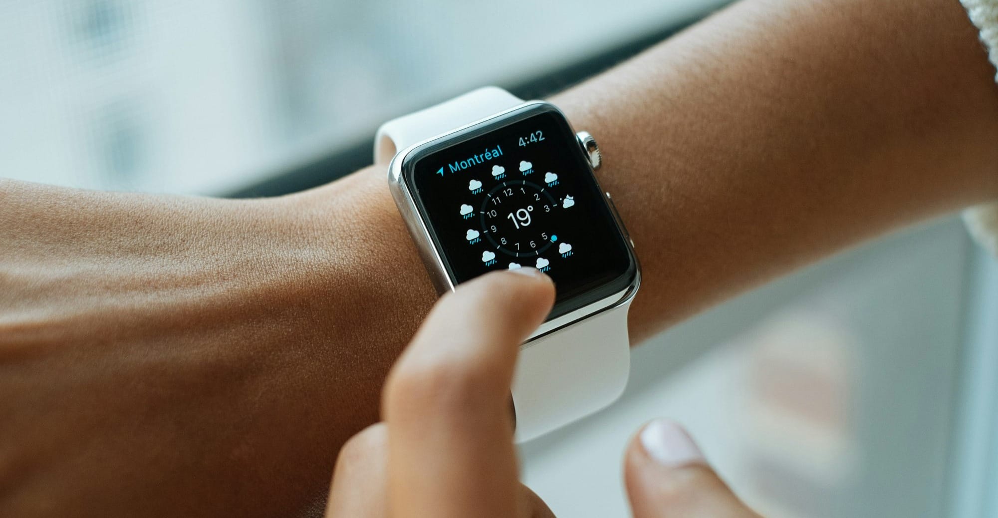 person wearing silver aluminium case Apple Watch with white Sports Band