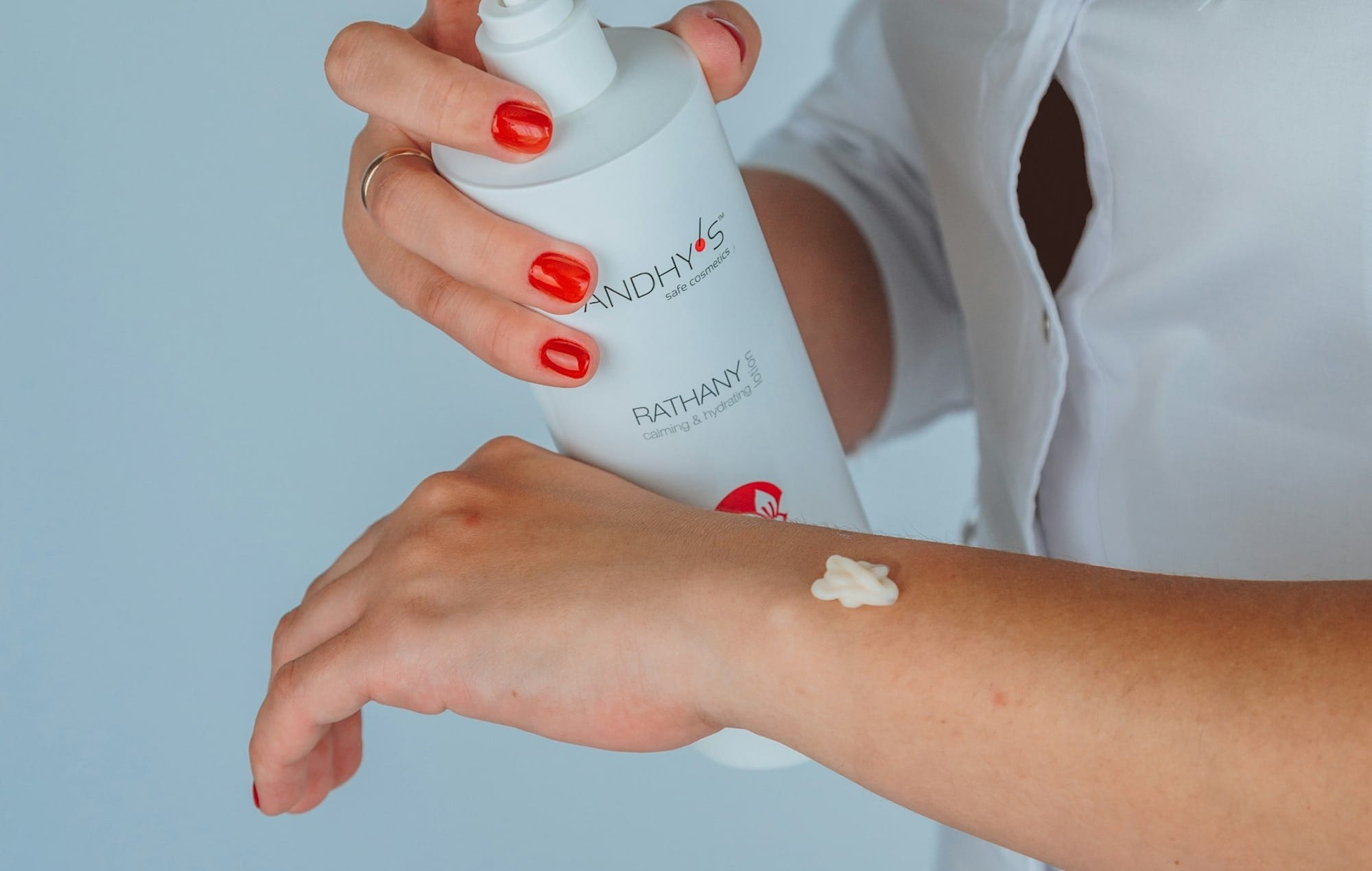 woman in white button up shirt holding white plastic bottle